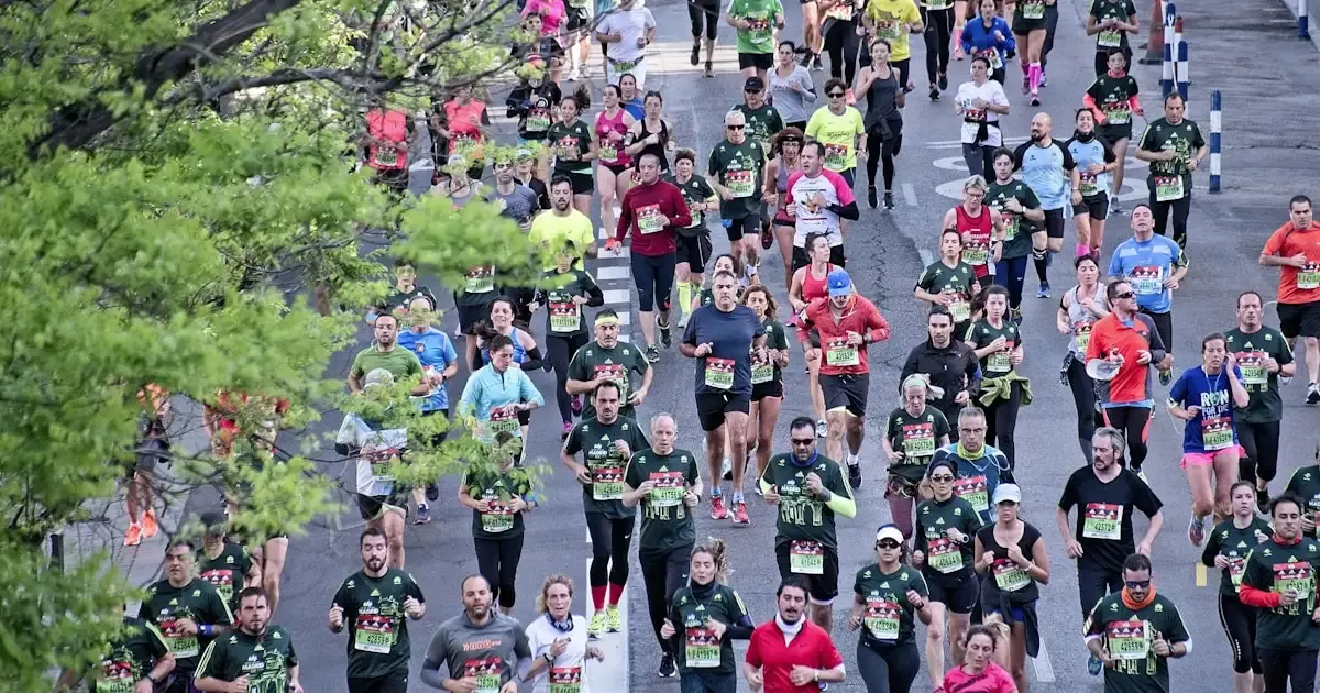 Multidão de corredores em prova de rua com camisetas esportivas do evento