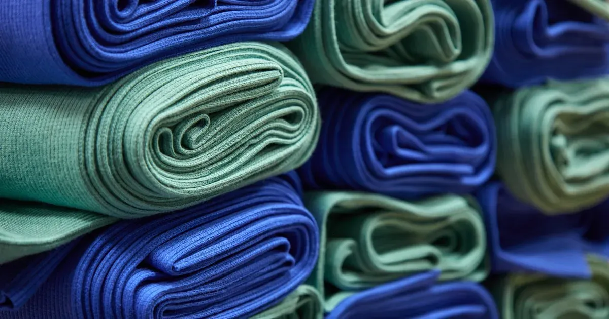 Malhas dobradas e empilhadas em tons de azul e verde