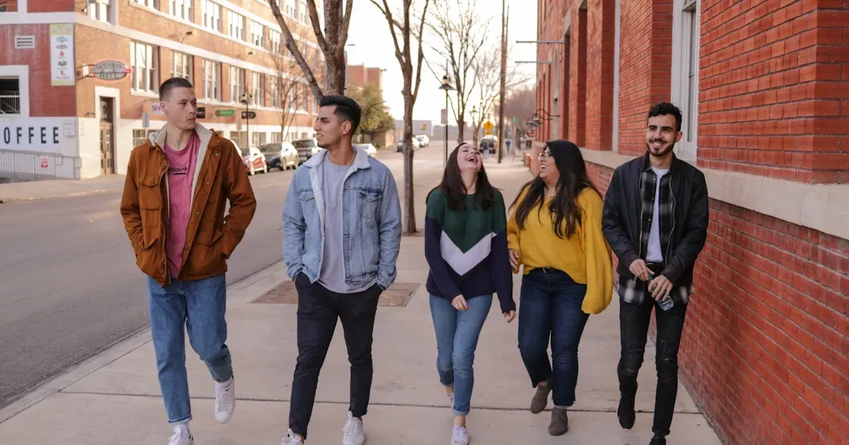 Turma de amigos caminhando e rindo juntos na rua