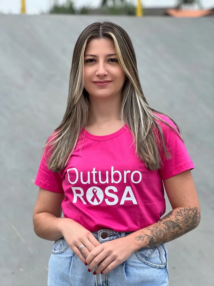 Camiseta pink de Outubro Rosa com o laço da campanha estampado dentro da letra O
